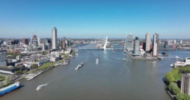 Hollanda 'daki Rotterdam şehrinin silueti Maas ve ofis binalarının manzarasına bakıyor. Varış yeri Hollanda. Erasmusbrug ve nehir Maas şehir manzarası.