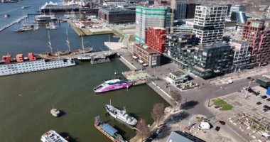 Amsterdam, 19 Mart 2022, Hollanda 'da. NDSM feribotu modern sanayi tersanesine ve son moda yerleşim alanına geliyor. Toplu taşıma yolcularının GVB Ijveer gelişi hava aracı görüntüsü.