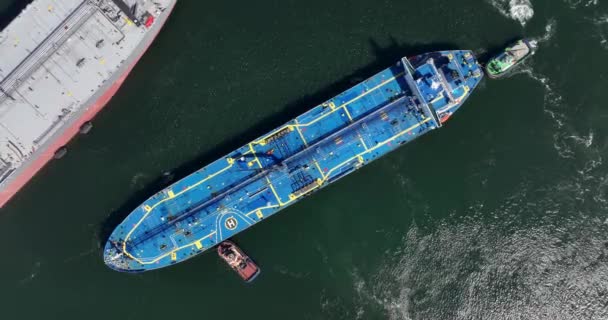 Rotterdam, 18th of april 2022, The Netherlands. Crude Oil Tanker ship Alhani being docked in the harbour by a tugboat marine vessel. Aerial drone view — стоковое видео
