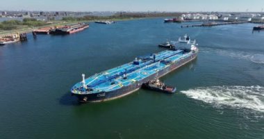 Rotterdam, 18 Nisan 2022, Hollanda 'da. Ham Petrol Tankeri gemisi Alhani bir römorkör gemisiyle limana yanaşıyor. Hava aracı görünümü