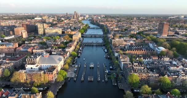 Амстердам, 24 апреля 2022 года, Нидерланды. Вид на город с реки Амазонки и канала домов Магере Брюг и Карре в центре города. Достопримечательности и достопримечательности. — стоковое видео
