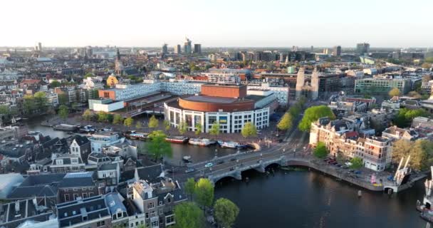 Амстердам, 24 апреля 2022 года, Нидерланды. Городской вид на реку Амстел и канал домов ратуши stopera центра города. Туристические достопримечательности достопримечательности. Балетный зал — стоковое видео