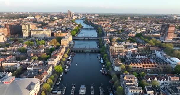 Amsterdam, 24 aprile 2022, Paesi Bassi. Vista della città del fiume Amstel e case sul canale Magere Brug e Carre theather centro città. Luoghi di interesse turistico. — Video Stock