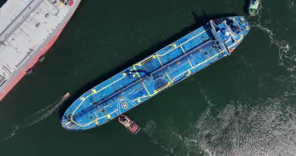 Rotterdam, 18th of april 2022, The Netherlands. Crude Oil Tanker ship Alhani being docked in the harbour by a tugboat marine vessel. Aerial drone view — стоковое видео