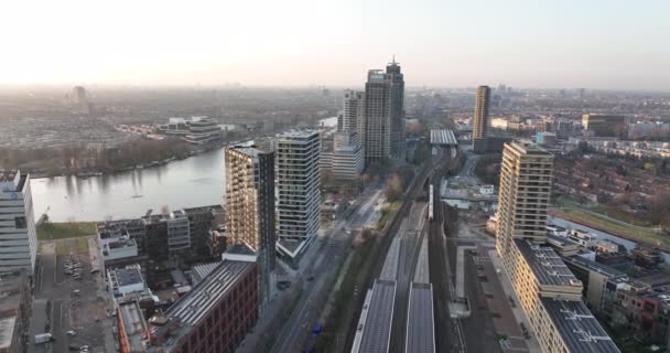 Amsterdão, 23 de março de 2022, Países Baixos. Prédios de escritórios Omval. Skyline aéreo ao longo do rio e Amstel estação de infra-estrutura urbana distrito de negócios. Rembrandt torre paisagem urbana. — Vídeo de Stock