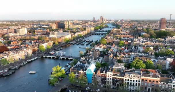 Амстердам, 24-й апріл 2022, Нідерланди. Міський краєвид на річку Амстел і канал будинків Magere Brug і Carre theather city center. Туристичний краєвид. — стокове відео