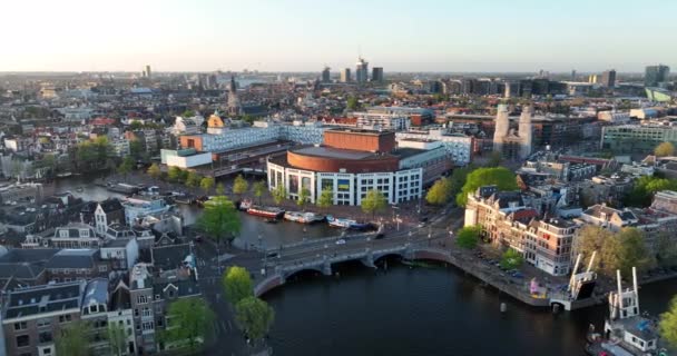 Amszterdam, 2022. április 24., Hollandia. Kilátás a folyóra Amstel és csatornák házak Városháza stopera városközpont. Turisztikai látnivaló városnézés. Balett terem — Stock videók