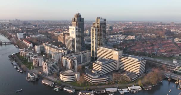 Amsterdam den 23 mars 2022, Nederländerna. Omval kontorsbyggnader. Skyline antenn längs floden och Amstel station infrastruktur urban affärsdistrikt. Rembrandt Tower stadsbild. — Stockvideo