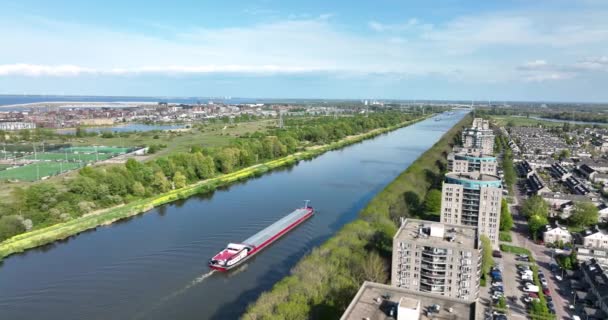 Inland shipping logistics transportation of goods over water way infrastructure in the Netherlands Amsterdam Rijnkanaal. Barge sailing shipment of freight aerial drone view. — Stockvideo