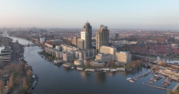 アムステルダム、 2022年3月23日、オランダ。オフィスビルだ。川とアムステル駅インフラ都市ビジネス地区に沿ってスカイライン航空。レンブラントタワーの街並み. — ストック動画