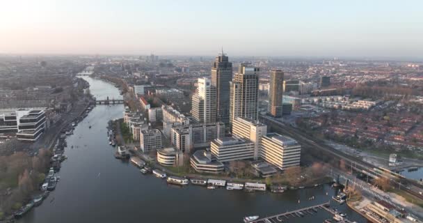 Amsterdão, 23 de março de 2022, Países Baixos. Prédios de escritórios Omval. Skyline aéreo ao longo do rio e Amstel estação de infra-estrutura urbana distrito de negócios. Rembrandt torre paisagem urbana. — Vídeo de Stock