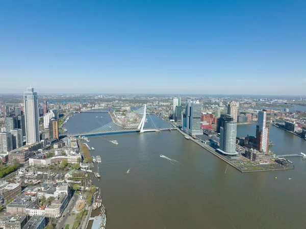 Hollanda 'daki Rotterdam şehrinin silueti Maas ve ofis binalarının manzarasına bakıyor. Varış yeri Hollanda. Erasmusbrug ve nehir Maas şehir manzarası.