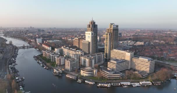 アムステルダム、 2022年3月23日、オランダ。オフィスビルだ。川とアムステル駅インフラ都市ビジネス地区に沿ってスカイライン航空。レンブラントタワーの街並み. — ストック動画
