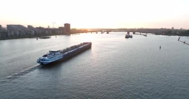 Amsterdam, 11 Mayıs 2022, Hollanda 'da. Ulaşım gemisi su yolu insansız hava aracı lojistik ve toplu mal ticaretini nehirdeki bir tekneyle görüyor..