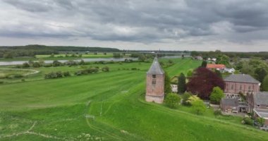 Hollanda 'nın Gelderland eyaletindeki Lower Rhine nehri kıyısındaki Heteren köyü nehrin hava aracı görüntüsü ve su boyunca binalar....