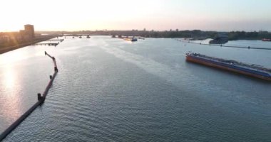 Amsterdam, 11 Mayıs 2022, Hollanda 'da. Ulaşım gemisi su yolu insansız hava aracı lojistik ve toplu mal ticaretini nehirdeki bir tekneyle görüyor..