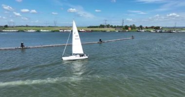 Yelkenli gemi eğlence aktivitesi. Hollanda 'da Hollanda yakınlarındaki Hollandalı su gölünde yelken açmadan önce küçük bir denizcilik teknesi açık havada yüzüyor..