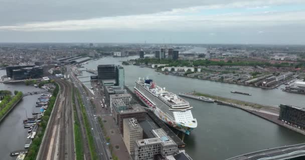 アムステルダム 2022年5月11日 オランダ Ij川の近くのアムステルダム市内中心部の旅客ターミナルでアムステルダムの港でノルウェーの休暇クルーズ船 — ストック動画