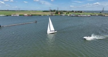 Yelkenli gemi eğlence aktivitesi. Hollanda 'da Hollanda yakınlarındaki Hollandalı su gölünde yelken açmadan önce küçük bir denizcilik teknesi açık havada yüzüyor..