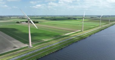 Rüzgar türbin sistemlerinden geçen rüzgar enerjisi üretimi. Yeşil sürdürülebilir alternatif elektrik üretimi, karbon ayak izini ve yeşil ev gazı emisyonunu azaltan rüzgar değirmenlerini kullanıyor. Hollanda 'da.