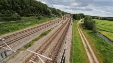Utrecht, 1st of July 2022, The Netherlands. NS train Nederlandse Spoorwegen FPV drone high speed follow through a grassland landscape. Sustainable travel mobility.