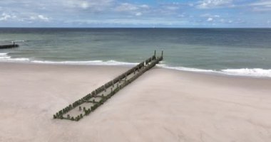 The Netherlands Holland sandy beach seashore coast dramtic scene shoreline. Waterline and break water wooden poles landscape along the Noordzee in Zeeland.