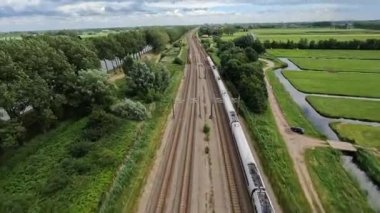 Utrecht, 1st of July 2022, The Netherlands. NS train Nederlandse Spoorwegen FPV drone high speed follow through a grassland landscape. Sustainable travel mobility.