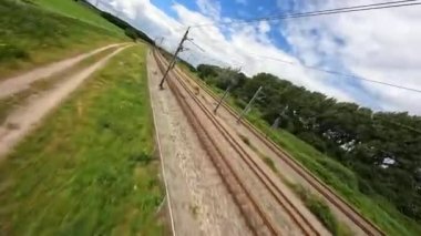 Utrecht, 1st of July 2022, The Netherlands. NS train Nederlandse Spoorwegen FPV drone high speed follow through a grassland landscape. Sustainable travel mobility.