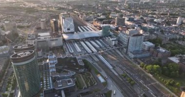 Utrecht silueti ve merkez istasyon toplu taşıma altyapısı ve iş bölgesi. Havadan insansız hava aracı görüntüsü. Şehir merkezindeki yüksek binalar ve kuleler.