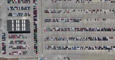 Top down aerial view of import and export car automobile storage in harbour port. Automotive industry new vehicles parked ready for shipping.