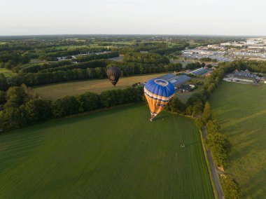 Barneveld, 3th of August 2022, The Netherlands. Bas Balloon rides. Balloon sailing landing in farm grassland field. Hot air balloon aircraft. Propelled by wind.
