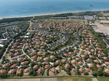 Vacation bungalow park accomodation leisure resort in Zeeland, The Netherlands. Summer cabin village cottage overhead drone aerial to spend holidays.
