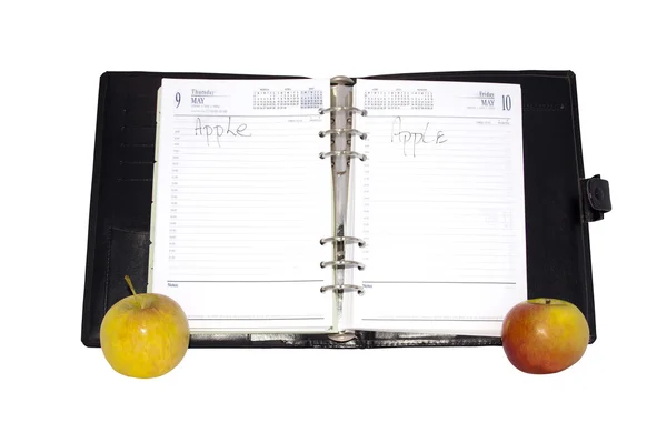 Açık bir günlük ile iki kırmızı ve sarı elmalar — Stok fotoğraf