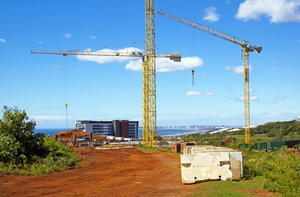 Estaleiro de construção com três torre guindaste lança contra azul Skyline — Fotografia de Stock