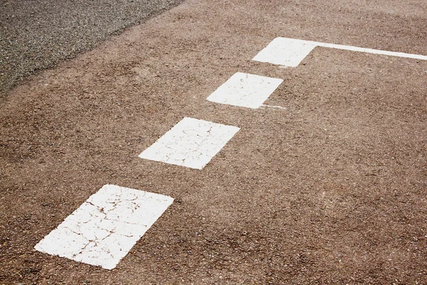 Vit målade avkastning tecken på asfalterad väg — Stockfoto