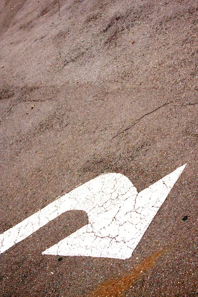 Seta pintada de branco indicando volta à esquerda na superfície da estrada — Fotografia de Stock