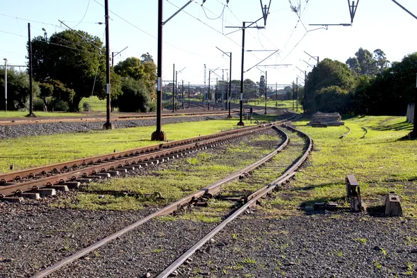 Trilhos ferroviários e tapume na paisagem rural — Fotografia de Stock
