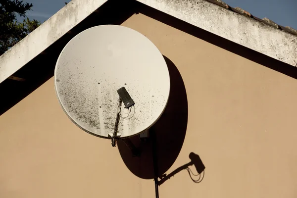 Plato de satelite descuidado montado en la pared de la residencia —  Fotos de Stock