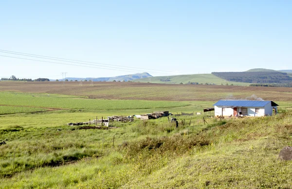 Tierra preparada para la agricultura con cabaña africana en primer plano — Foto de Stock