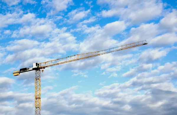 Grue à tour jaune contre ciel nuageux bleu — Photo