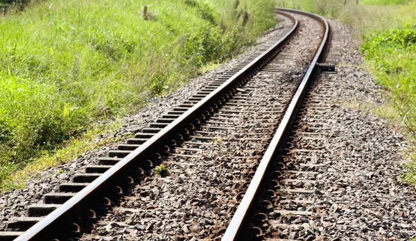 Trilho ferroviário curvo brilhante que atravessa o campo — Fotografia de Stock