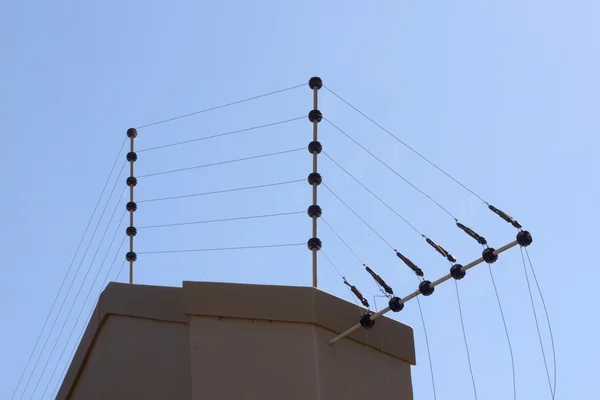 Электрический забор против голубого неба на границе стены — стоковое фото