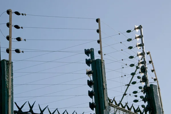 Extensa cerca eléctrica verde que rodea la propiedad residencial —  Fotos de Stock