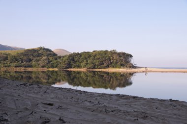 Ağaçlar ve gökyüzü göl yüzeyinde yansıyan
