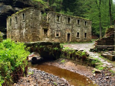 yüksek su seviyesi ile karanlık dağ nehir üzerinde ağır taşlı su değirmeni mahvetmek yağmurdan sonra göster.