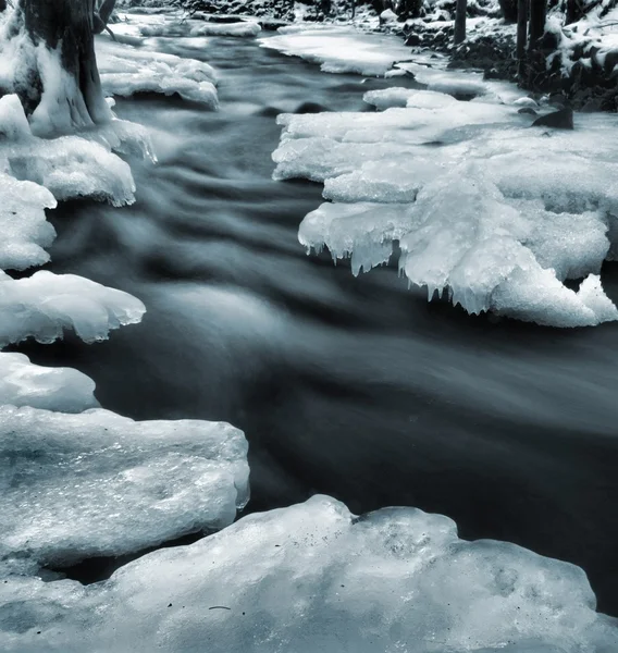 Nacht Winter Blick auf Eiszapfen und eisige Felsbrocken in den Bach. — Stockfoto