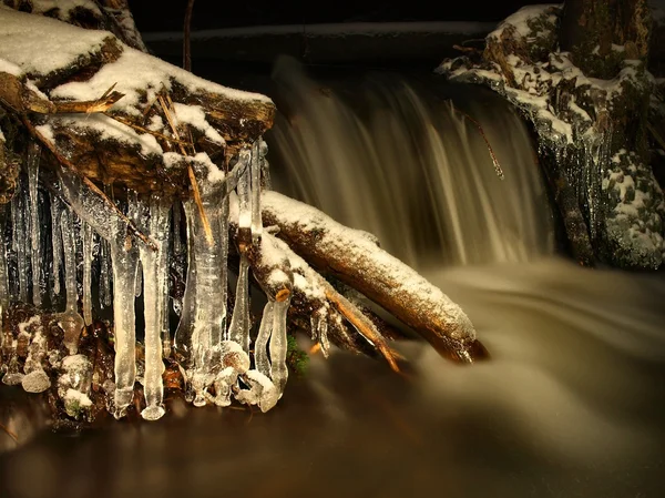 Vista noturna de inverno para icicles e pedras geladas no córrego . — Fotografia de Stock