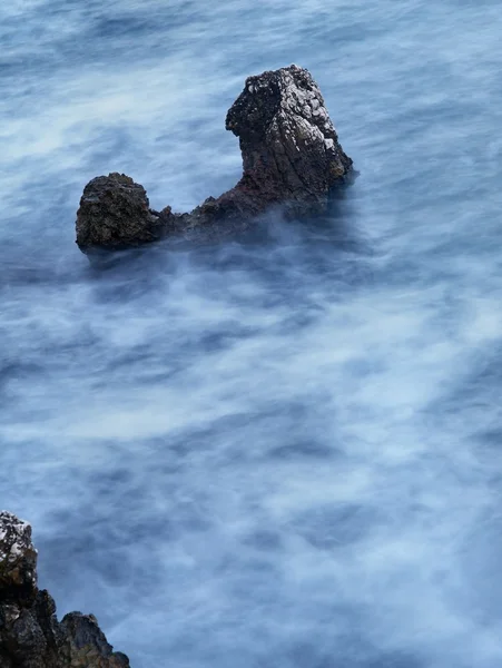 Rocks i blå urolige watter . - Stock-foto