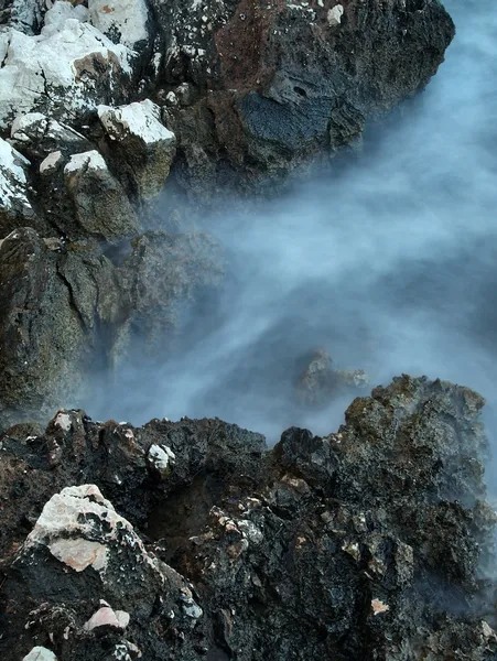 Rocks in blue troubled watter. — Stock Photo, Image