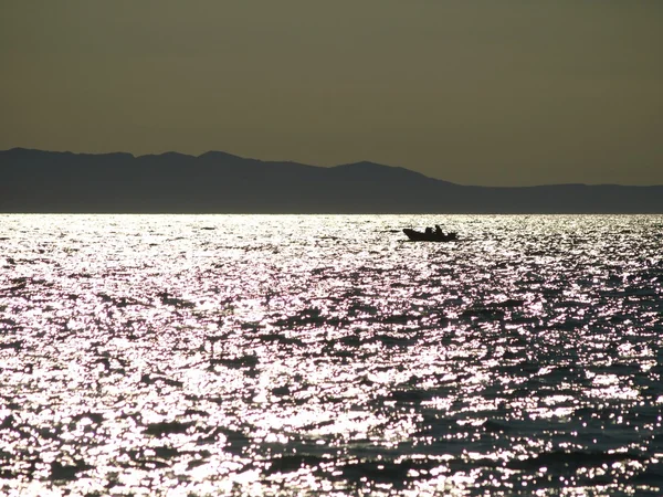 Ferienboot auf Meeresspiegel in Sonnenreflexionen auf Wellen. — Stockfoto